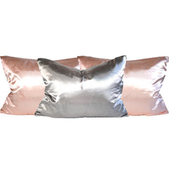 Three Standard size satin pillowcases with zipper closure with the colors being two pink and one grey.
